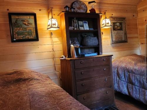 a bedroom with two beds and a dresser next to a dresser at Twin Bucks Cabin in Whiting