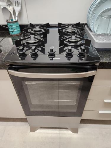 a black stove top oven in a kitchen at Incrível Apto 2 quartos próx Consulado Americano in Recife