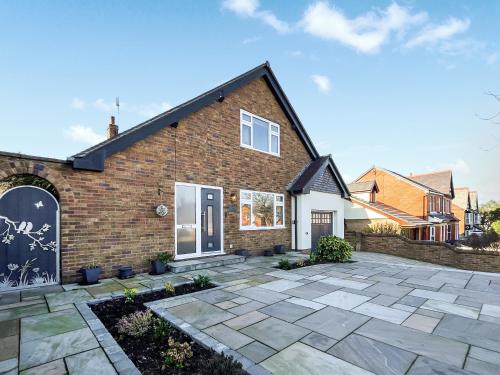 a brick house with a stone patio at Casa Rosa in Prestatyn