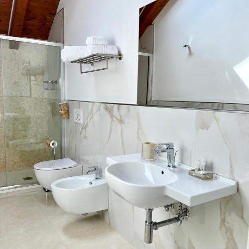 a white bathroom with a sink and a toilet at La Villa Carmelina in Agerola