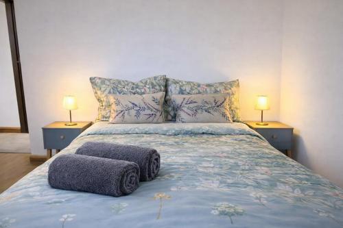 a bedroom with a bed with two lamps on two tables at 4-Bed Barnwell Retreat- Sleeps10 Garden & Parking in Stevenage