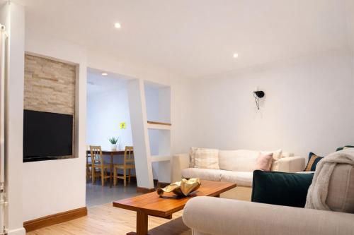 a living room with a couch and a table at 4-Bed Barnwell Retreat- Sleeps10 Garden & Parking in Stevenage