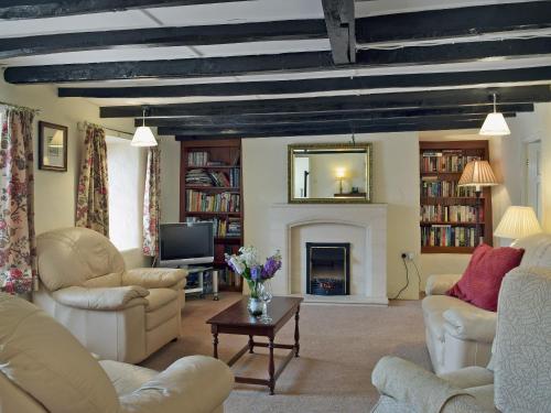 a living room with couches and a fireplace at Ty Cornel in Aberporth