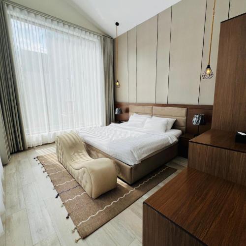 a bedroom with a bed and a chair in it at اكواخ سنتارا الريفيه in Taif