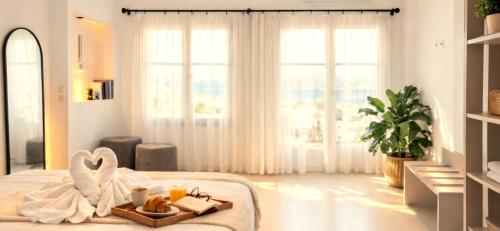a white bedroom with a tray of food on a bed at Knossos Sunrise in Palekastron
