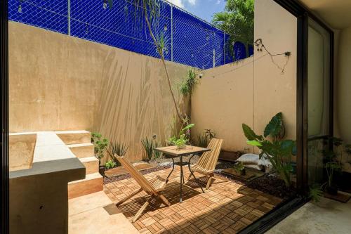 a patio with a table and chairs and a fence at Luxurious 2Br 2 5 Ba in Residential Neighborhood in Mérida