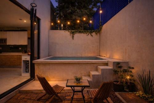 a backyard with a swimming pool and two chairs and a table at Luxurious 2Br 2 5 Ba in Residential Neighborhood in Mérida