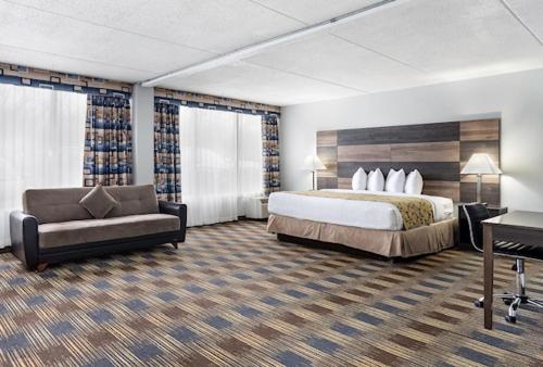 a hotel room with a bed and a couch at Baymont by Wyndham - Chicago - Addison - O'Hare in Addison