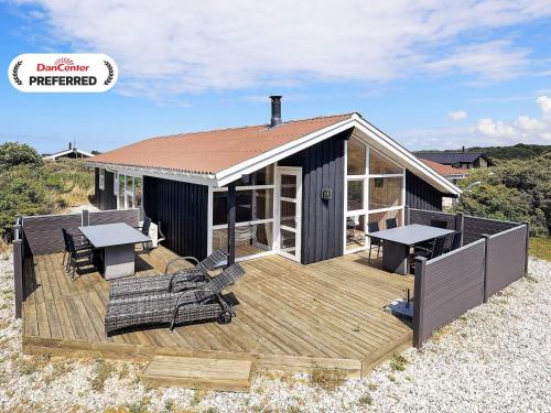 a house with a deck with tables and chairs at Cozy Coastal Retreat - By Traum Ferienwohnungen in Hjørring