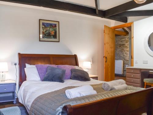 a bedroom with a large bed with purple pillows at The Hayloft - Uk50027 in Liskeard