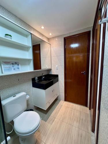 a bathroom with a white toilet and a sink at Elegance Residences Cumbuco in Cumbuco