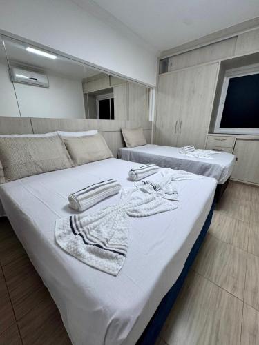two beds with towels on top of them in a room at Elegance Residences Cumbuco in Cumbuco