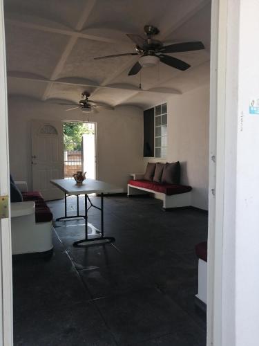 a living room with a table and a ceiling fan at Bungalow Josefina flores in Lo de Marcos