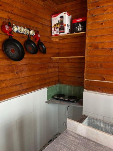 a small kitchen with wooden walls and a stove at Surf house in Essaouira