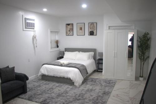 a white bedroom with a bed and a couch at Ekimo Elite Leisure in Jersey City