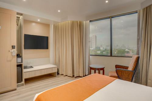 a hotel room with a bed and a large window at City Garden Hotel Makati in Manila