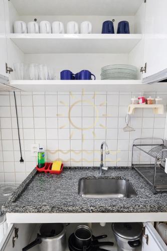 a kitchen counter with a sink and some dishes at Apto Porto de Galinhas in Porto De Galinhas