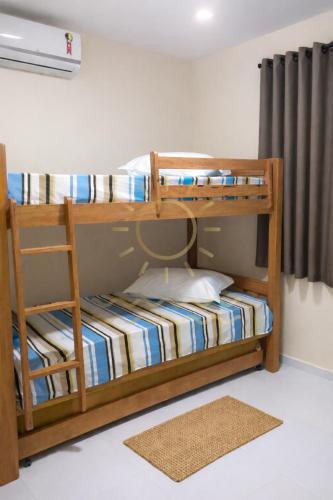 two bunk beds in a room with a rug at Apto Porto de Galinhas in Porto De Galinhas