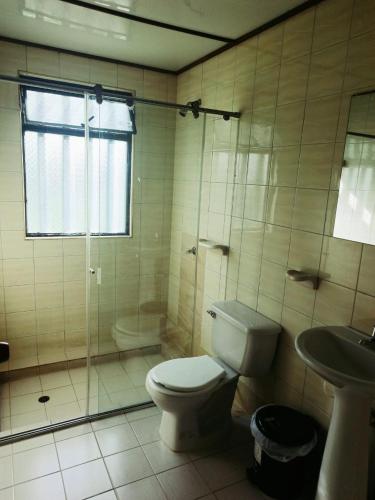 a bathroom with a toilet and a shower and a sink at Alborada Chinauta in La Serena