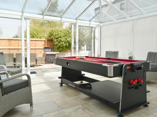 a pool table in a conservatory with a pool table at Bank Lane House in Freckleton