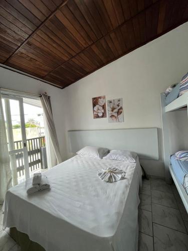 a white bed in a room with a window at Hotel Morada de Leste Pontal in Pontal do Paraná