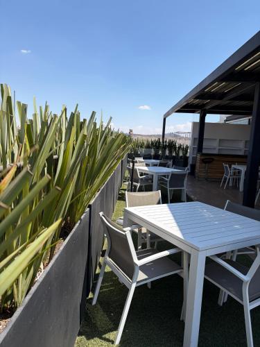 a table and chairs on a patio with plants at Hotel Nube, Puebla Centro in Puebla