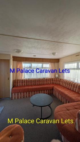 a waiting room with red chairs and a table at R6 North Shore Holiday Park in Winthorpe