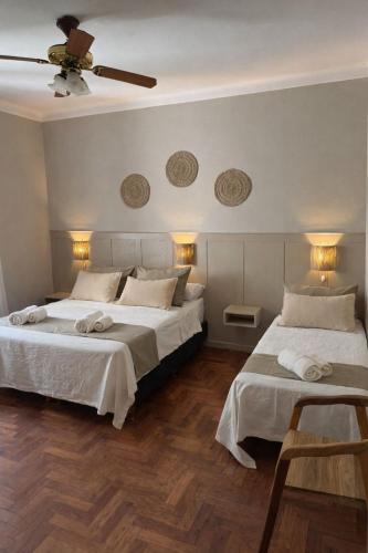 a bedroom with two beds and a ceiling fan at Hotel Ideal in Miramar