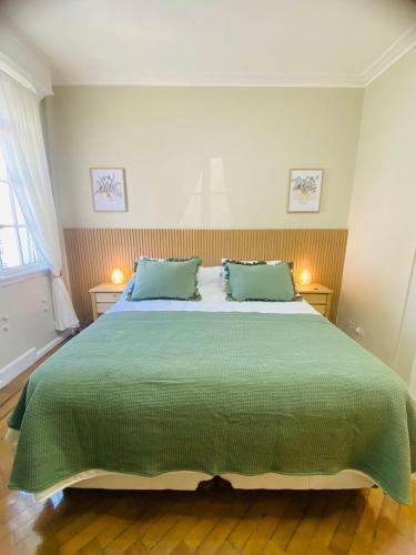a bedroom with a large green bed with two pillows at Iconic Obelisco Studio in Buenos Aires