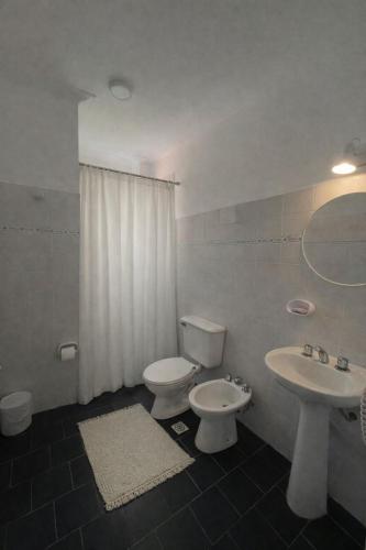a bathroom with a toilet and a sink at Hotel Ideal in Miramar