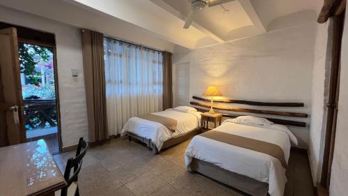 a hotel room with two beds and a table and a lamp at Hotel Sol de Ica in Ica