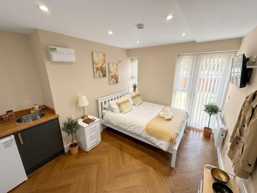 a small bedroom with a bed and a sink at 30C The Luxury Studios near Arsenal and Central London in London
