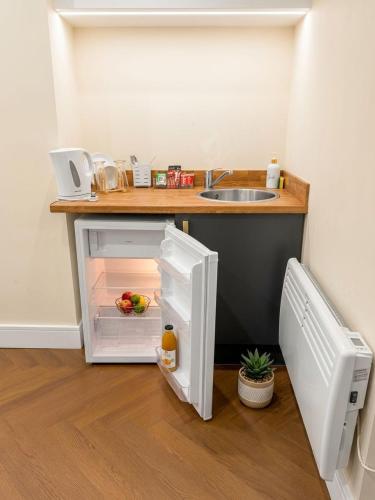 a small refrigerator with its door open in a kitchen at 30C The Luxury Studios near Arsenal and Central London in London