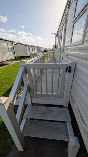 a white chair sitting on the side of a house at R6 North Shore Holiday Park in Winthorpe