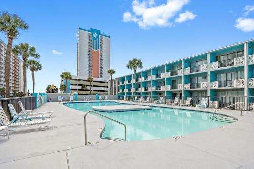 a swimming pool in front of a hotel at Lovely Pool Front Studio in Myrtle Beach