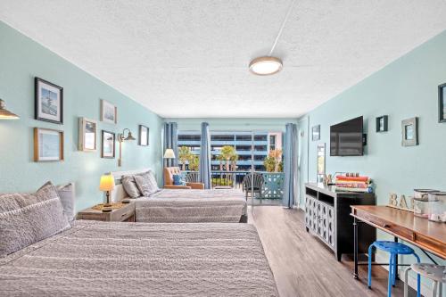 a bedroom with two beds and a couch at Lovely Pool Front Studio in Myrtle Beach