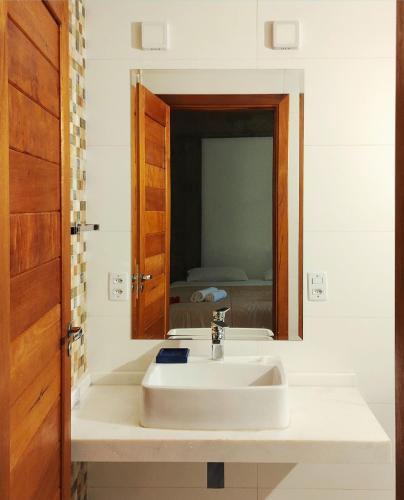 a bathroom with a white sink and a mirror at Pousada Samambaia in Paraty