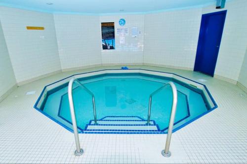 a large swimming pool with stairs in a room at Renovated Chalet at Mystic Springs, Pool, Hot Tub! in Canmore