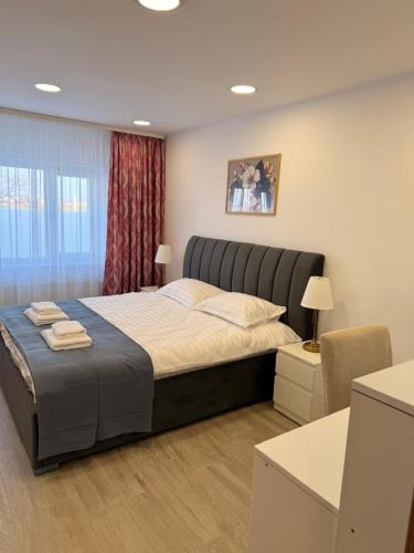a bedroom with a large bed in a room at Best4You Apartment Therme Airport in Baloteşti