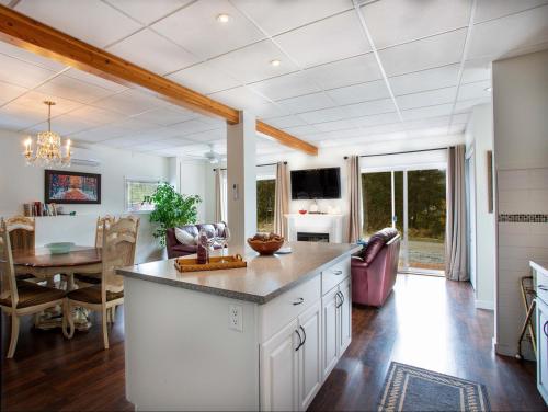 a kitchen with a table and a dining room at Pet Friendly Licensed Suite on Haskap Farm in Kelowna