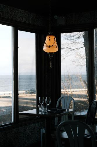 un tavolo con bicchieri da vino e una lampada davanti a una finestra di Auberge La Marmite a La Malbaie