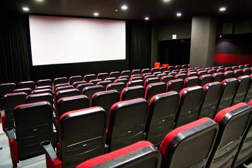 an empty auditorium with red chairs and a white screen at QUEST HOTEL - dawniej Hotel Planeta in Brzesko