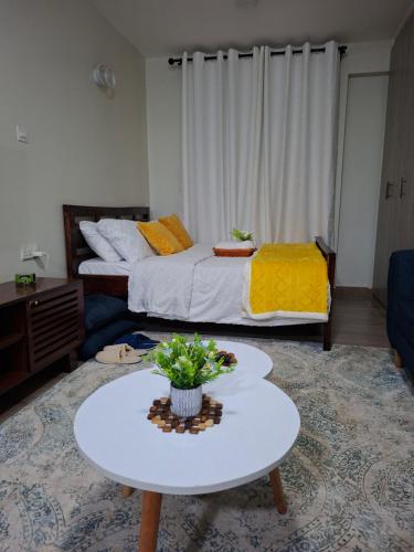 a living room with a bed and a table in front of it at BlueByMis in Muchatha