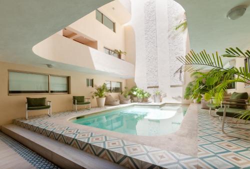 an indoor pool in a house with plants at Ocean Plaza by Zamá Homes in Playa del Carmen