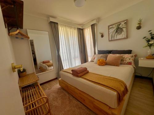a bedroom with a large bed and a large window at Ocean Breeze in Perth