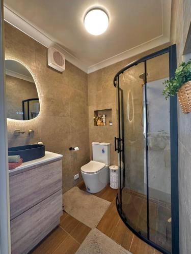 a bathroom with a shower and a toilet and a sink at Ocean Breeze in Perth