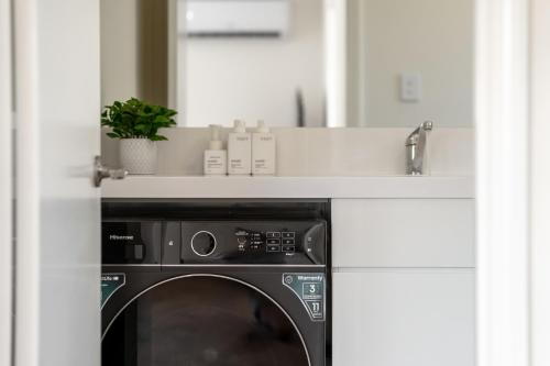 a kitchen with a washing machine with a counter above it at Modern Family Home Near Fiona Stanley & Murdoch Uni in Perth