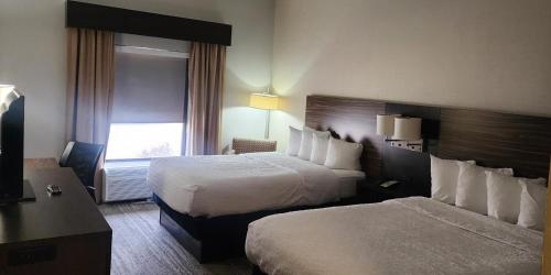 a hotel room with two beds and a window at Baymont by Wyndham Midland TX in Midland