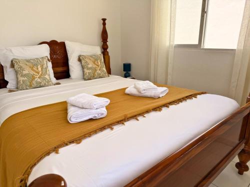 a bed with two towels sitting on top of it at Sweet Nest Villa in Sainte-Rose