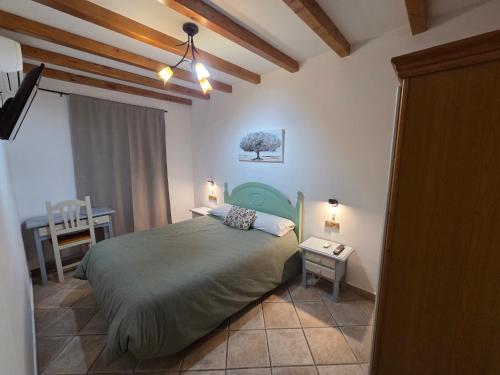 a bedroom with a bed and a table and a desk at Hostal Carlos I in Herrera del Duque
